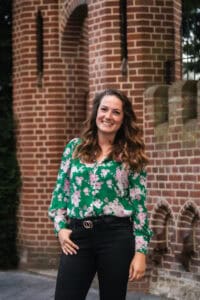 Dierenshop Sittard, vriendelijke medewerker in bloemrijke blouse voor dierenbenodigdheden.
