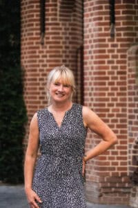 Gezicht vrouw voor dierenwinkel Dierenshop Sittard met brick gevel achtergrond.